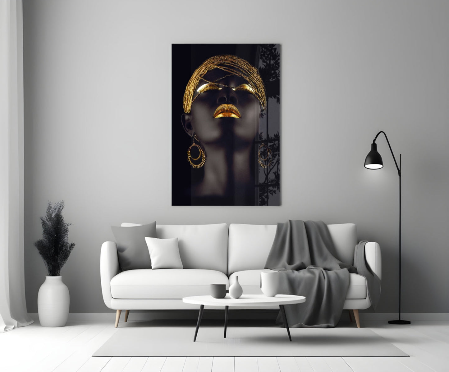 Modern living room with a white sofa, coffee table, and decorative wall art of a woman's face with gold accents. Gold Beaded Headdress Woman Glass Wall Art