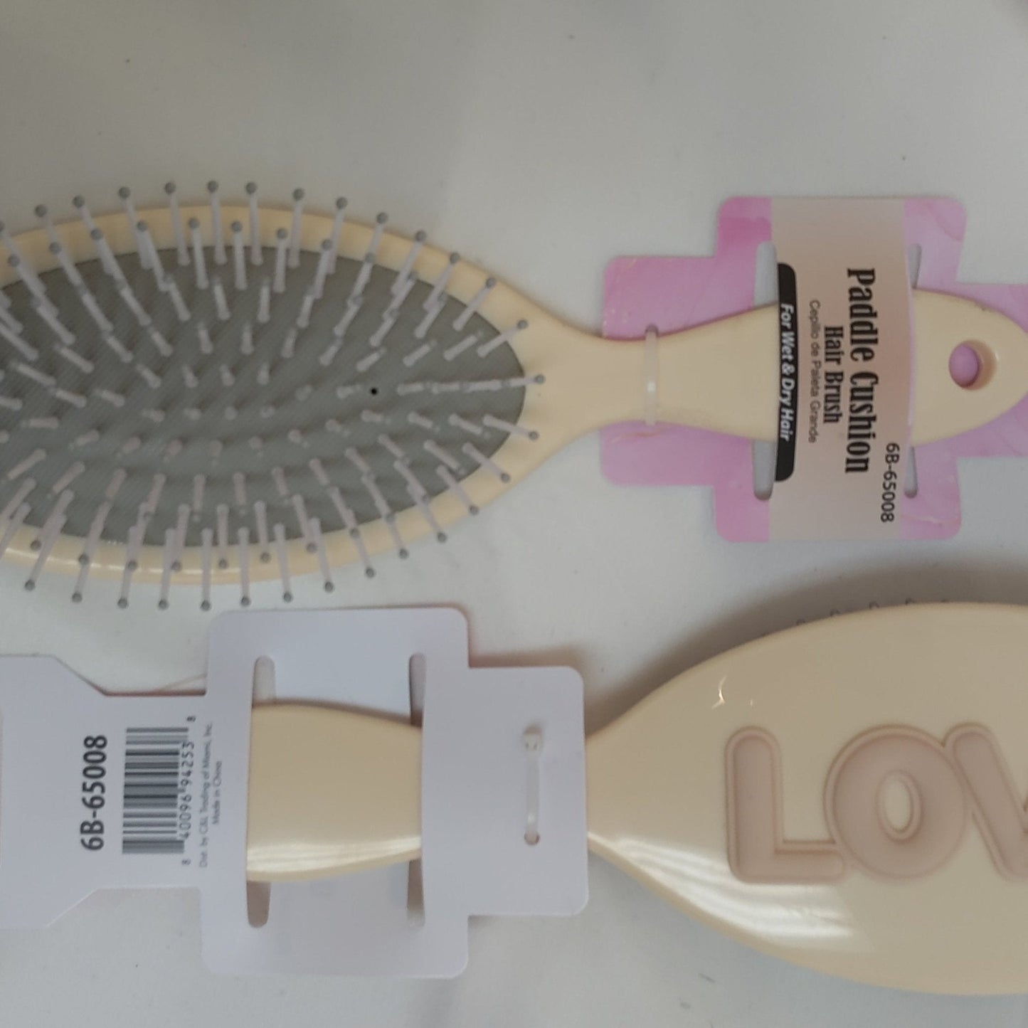 Paddle hair brush with pink handle and 'LOVE' text on a white background