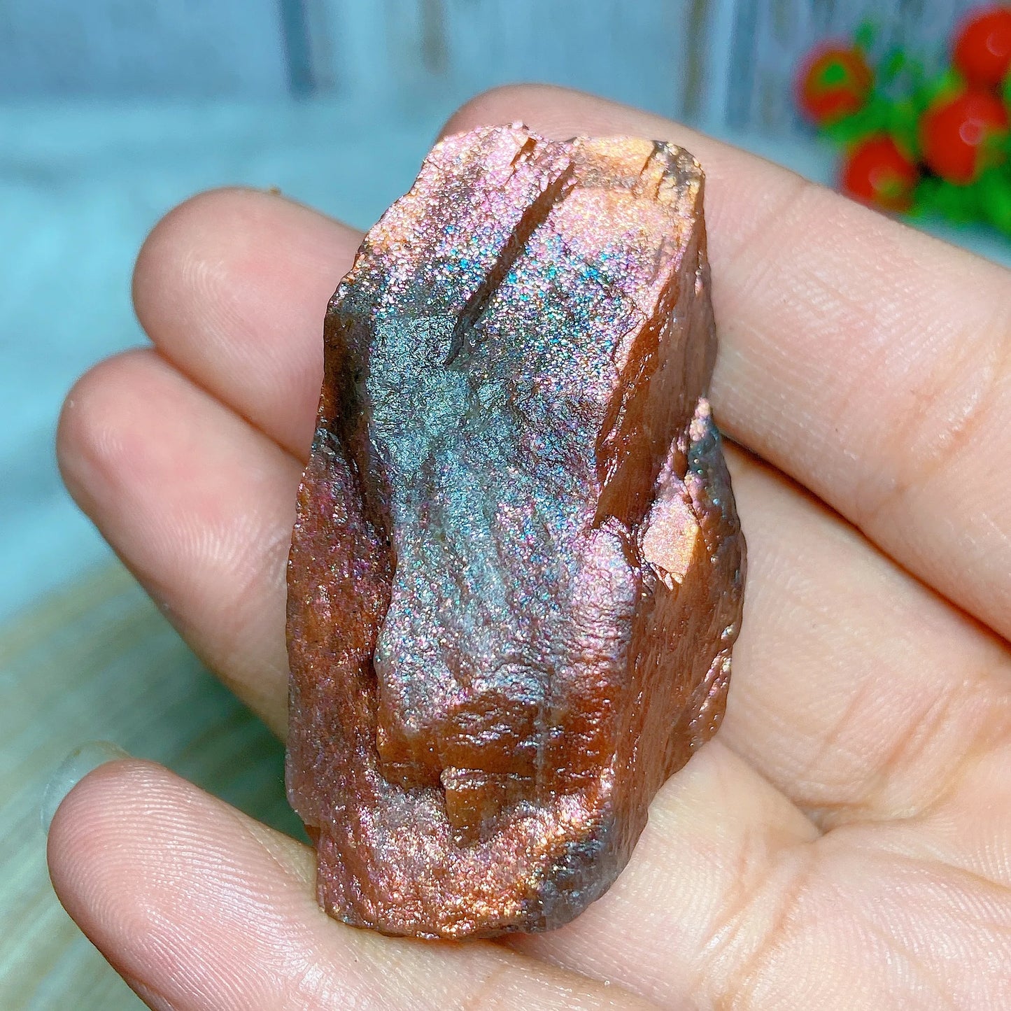 Raw copper ore held in a hand with a blurred background