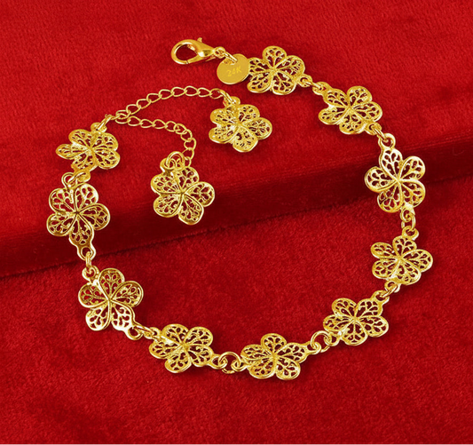 Gold bracelet with floral designs on a red background