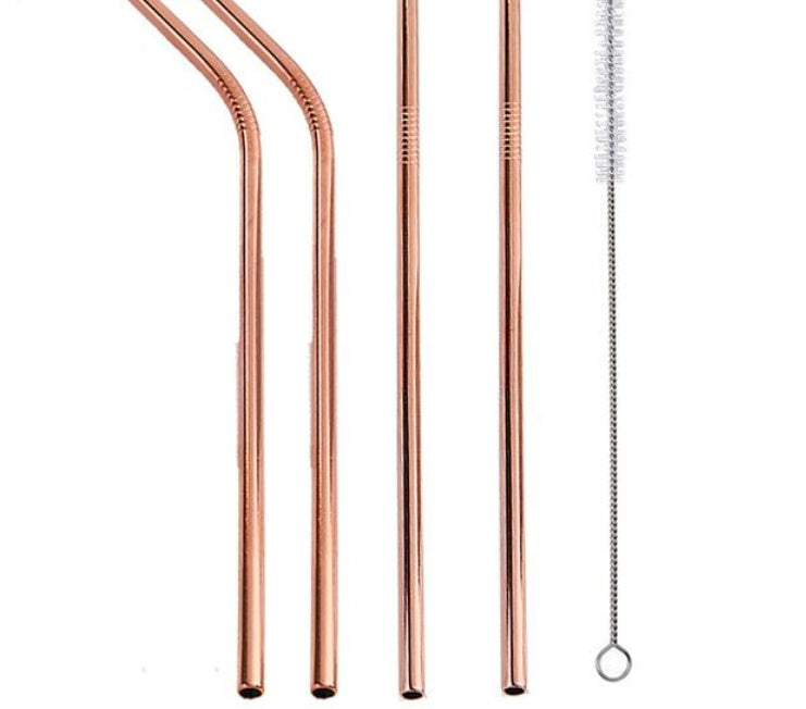 Set of rose gold metal straws with cleaning brush on a white background