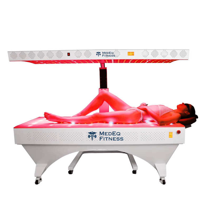 Person lying on a Medeq Fitness LED light therapy bed with red light therapy panel.
